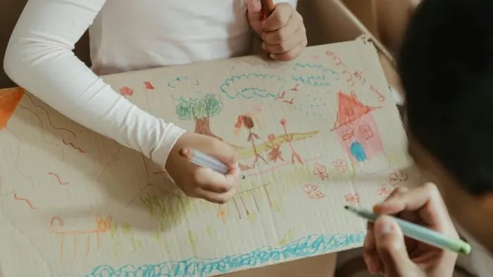 Kid Drawing On A Cardboard