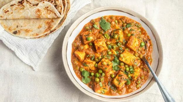 Mattar paneer in a bowl with sabzi