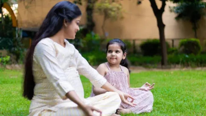 Indian kids doing yoga with parents