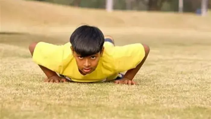 Kid doing push ups in grass
