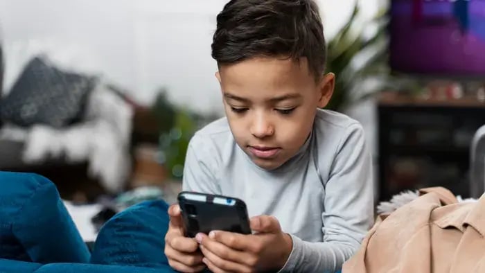 Boy usinh phone while sitting