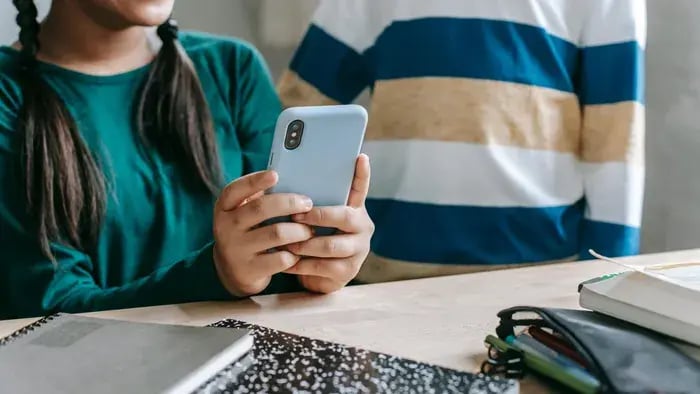 Girl using phone while sitting