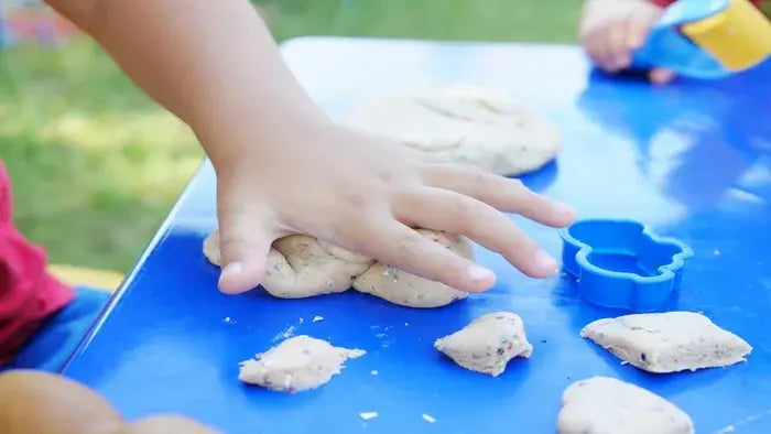 kid playing with clay with hands