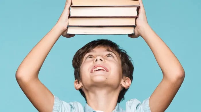 A Happy Boy Holding Multiple Books