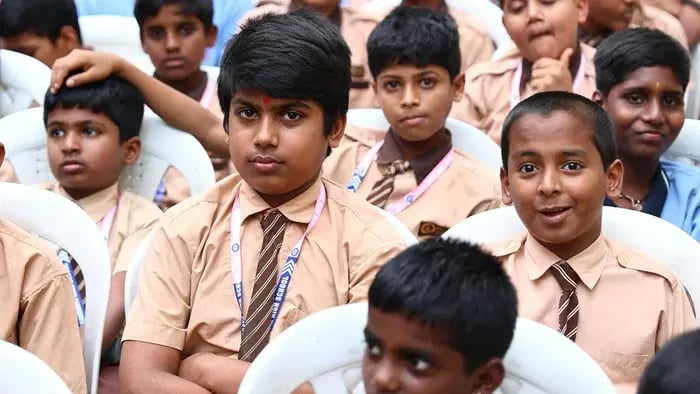 7 Reasons Why Students Should Wear Uniforms: Lessons in Equality and Discipline - Kids sitting in the school hall