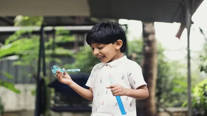 Boy playing with a bubble maker