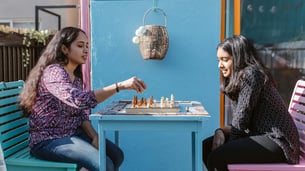 Girl playing chess with mother
