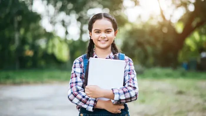 girl smiling with a book in her hand
