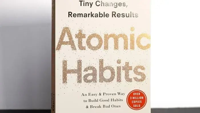 white book cover with atomic habits written in golden