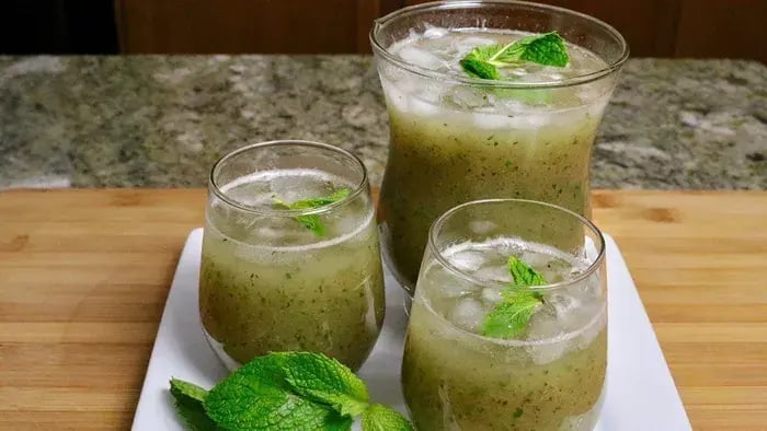 Three Glasses Of Raw Mango Sharbat Garnished With Mint Leaves