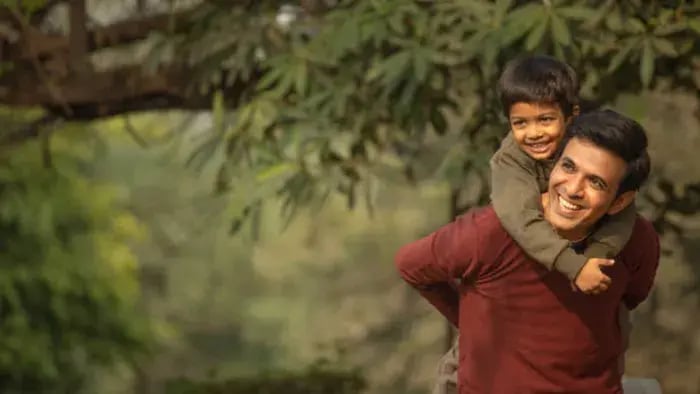 Indian son and father playing in park