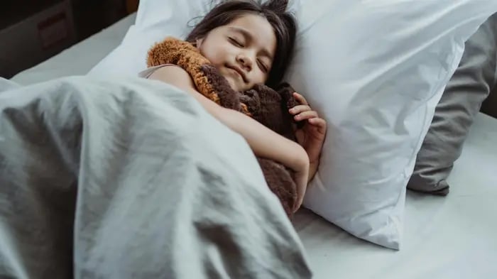 Kid Sleeping On A Bed