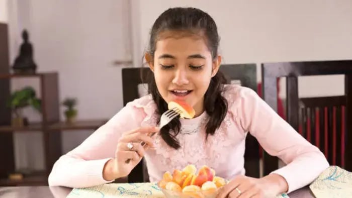 Indian kid eating fruit