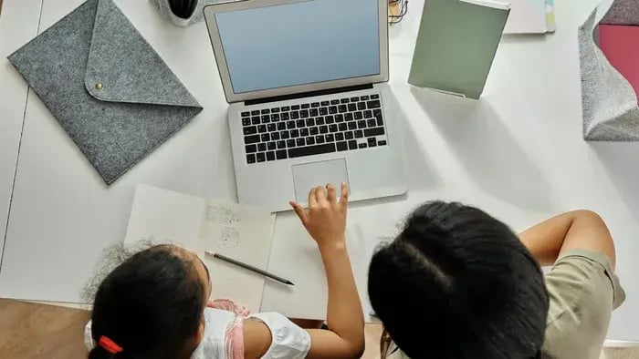 girl with mother using a laptop