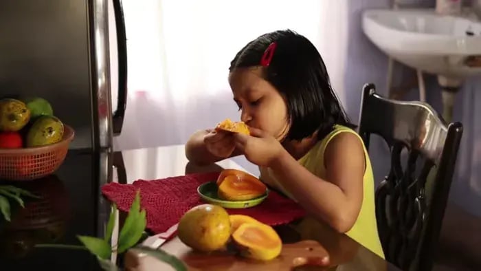 Indian kids eating mangoes