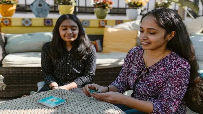 Mother and daughter sitting and playing cards