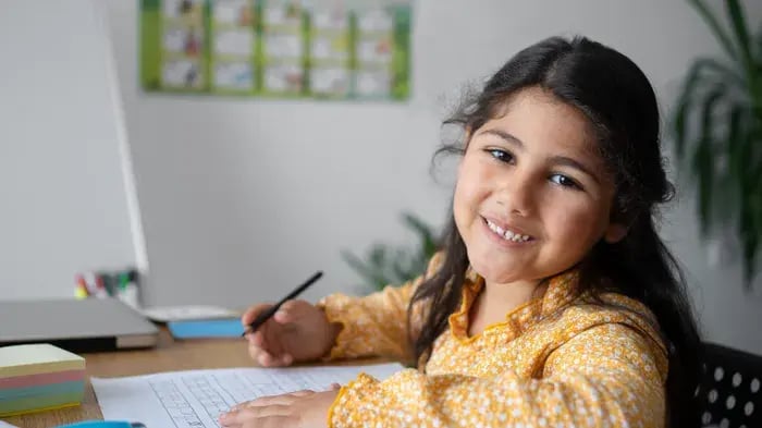 Girl Writing On A Desk