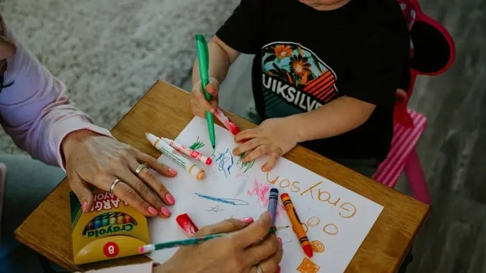 Indian mother is helping son draw
