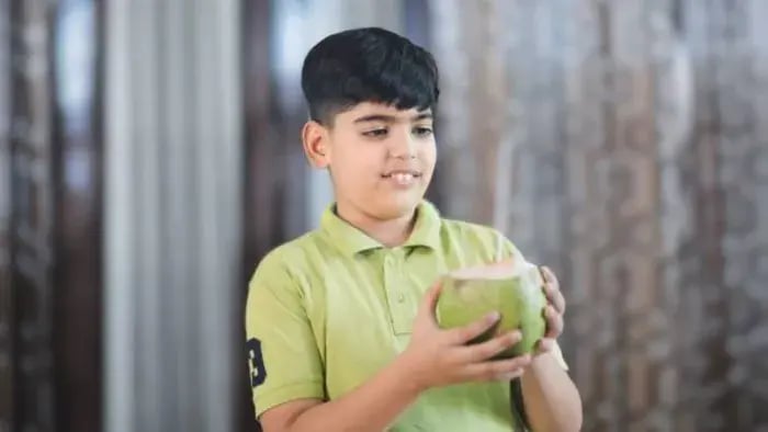 Indian kid drinking coconut water