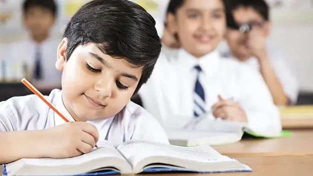 Kid Writing On A Desk