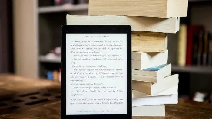 virtual book on a tablet and a stack of paper books
