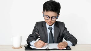 boy writing on a desk