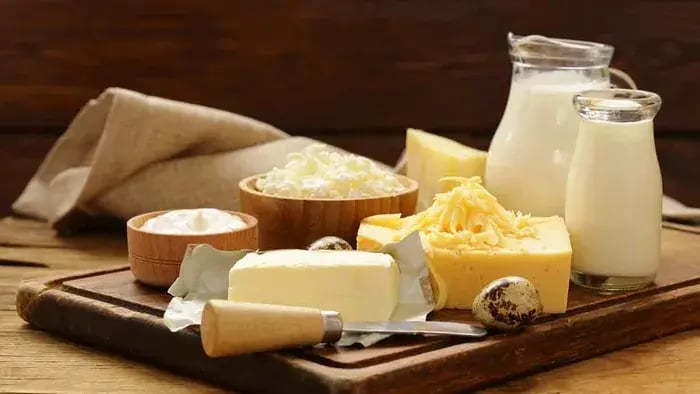 butter, milk, eggs, and cheese on a table