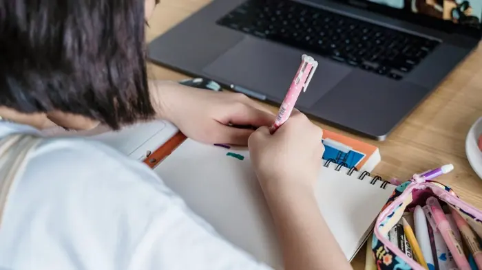 girl writing with pencil